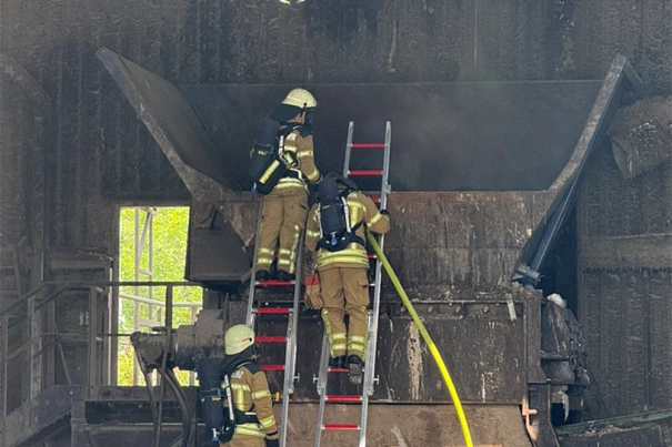Feuerwehrleute beim Löschen des Restabfallschredders.