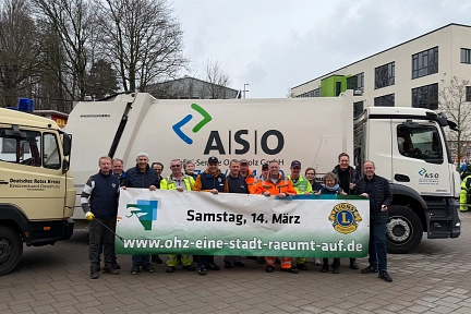 OHZ-räumt-auf-2026.jpg Die Initiatoren der Aktion stehen hinter einem Banner mit dem Datum der Veranstaltung vor einem Müllfahrzeug von der ASO. © Abfall-Service Osterholz